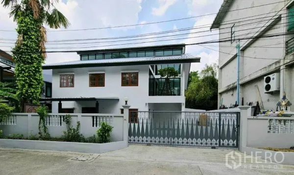 สำนักงานที่บ้าน ให้เช่าในLat Phrao, Bangkok - มุมมองหน้าบ้านของโฮมออฟฟิศสีขาว รีโนเวทใหม่ พร้อมรั้วและประตูบานใหญ่