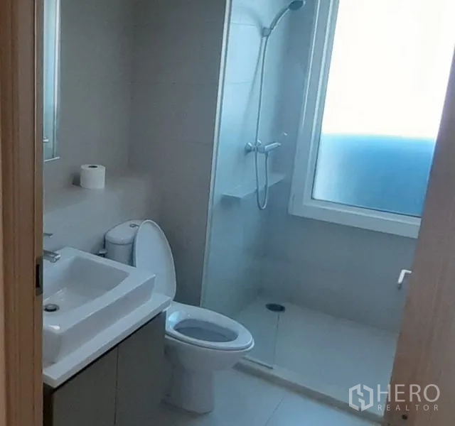 คอนโด ให้เช่าในKhlong Toei, Bangkok - ห้องน้ำโทนอ่อน พร้อมตู้ล้างหน้าทรงสี่เหลี่ยม สุขภัณฑ์ และพื้นที่อาบน้ำติดหน้าต่าง