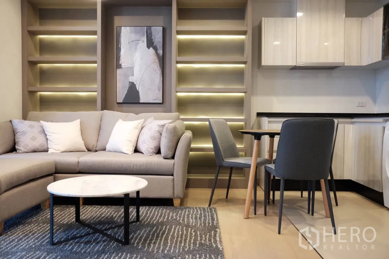 คอนโด ให้เช่าในWatthana, Bangkok - พื้นที่นั่งเล่นแบบโอเพ่นแพลน โซฟา L โต๊ะทานข้าว ครัวขนาดกะทัดรัด และชั้นไฟแบ็กไลต์