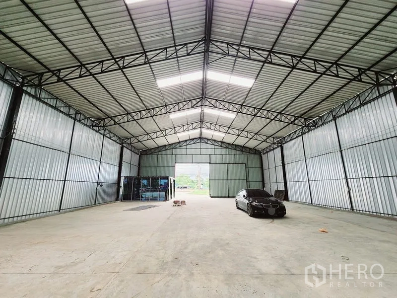 货栈 出租在Sam Phran, Nakhon Pathom - 从仓库深处望去的开阔空间，高挑人字形屋顶与钢桁架。