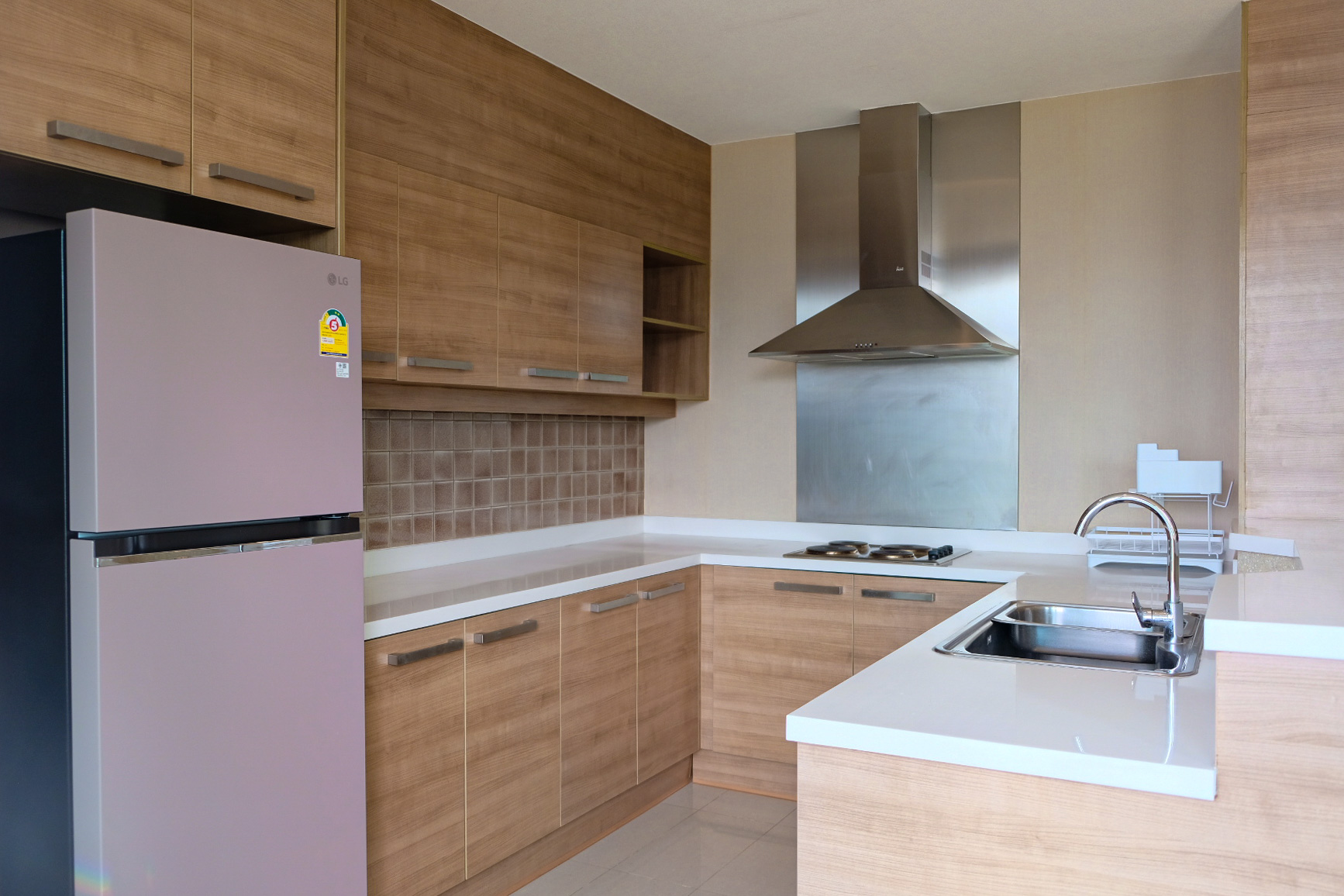 公寓 出租在Watthana, Bangkok - 厨房角度展示冰箱、炉灶、水槽与充足收纳。