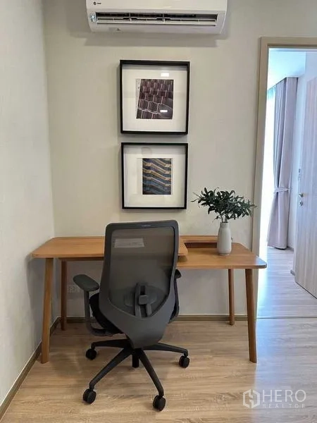公寓 出租在Ratchathewi, Bangkok - 居家办公角，木质书桌、人体工学椅与挂画。
