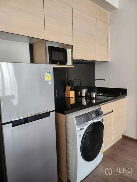 คอนโด ให้เช่าในKhlong Toei, Bangkok - ครัวบิวท์อินโทนไม้ เคาน์เตอร์หินสีดำ พร้อมตู้เย็น ไมโครเวฟ และเครื่องซักผ้า