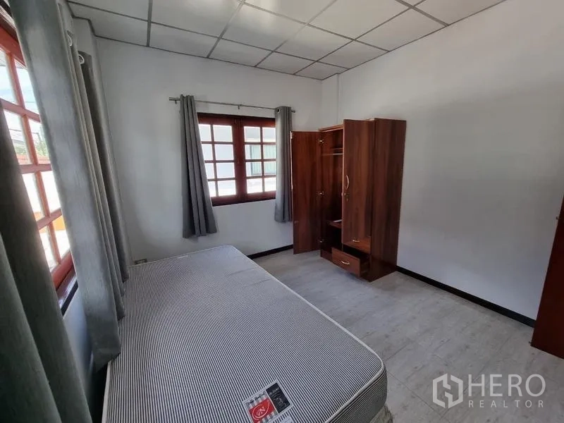 独立式住宅 出租在Nonthaburi - 温馨次卧，单人床、衣柜和两扇窗。