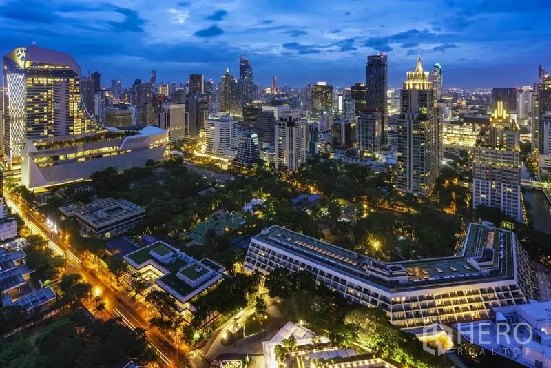 คอนโด ขายในPathum Wan, Bangkok - ทิวทัศน์สกายไลน์ย่านปทุมวัน กรุงเทพฯ ยามค่ำ พร้อมแสงไฟเมืองและพื้นที่สีเขียว ใกล้ BTS เพลินจิต