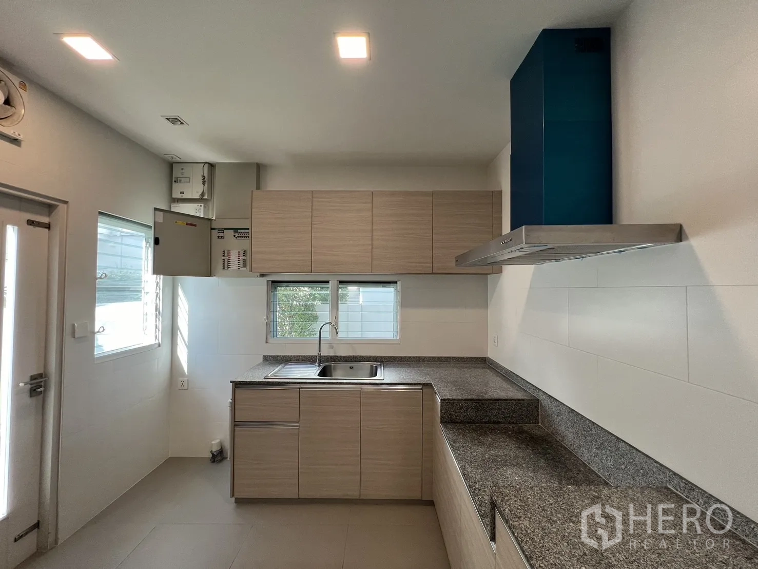 独立式住宅 出租在Prawet, Bangkok - 厨房配花岗岩台面、吊柜与抽油烟机。