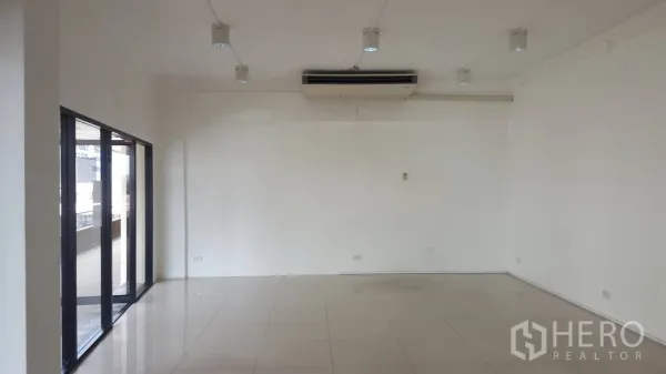 Office Space for rent in Khlong Toei, Bangkok - Open workspace with ceiling spotlights, air-conditioning and floor-to-ceiling glass panels on the side.