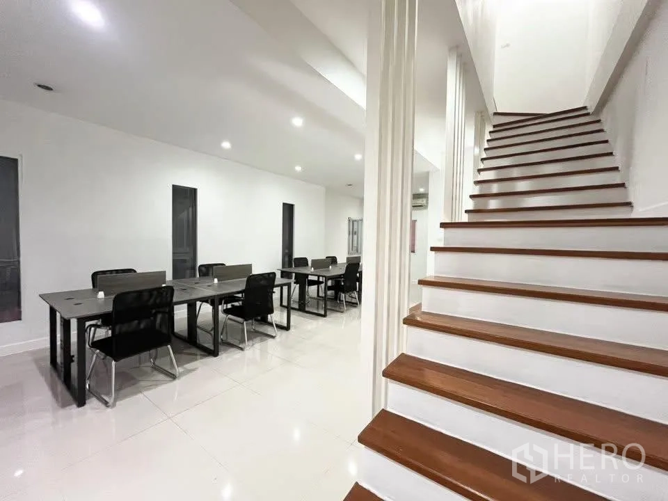 Home Office for rent in Bueng Kum, Bangkok - View of wooden staircase next to long open-plan workspace with desks and downlights