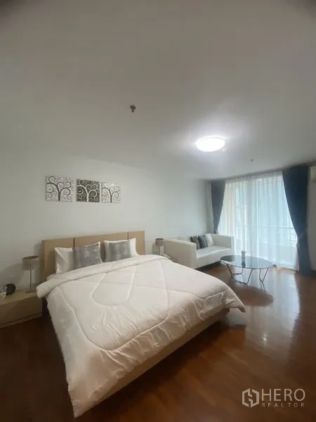 คอนโด ให้เช่าในPathum Wan, Bangkok - ห้องนอนกว้างพร้อมมุมนั่งเล่น เตียงนอน และทางออกสู่ระเบียงผ่านม่านโปร่ง