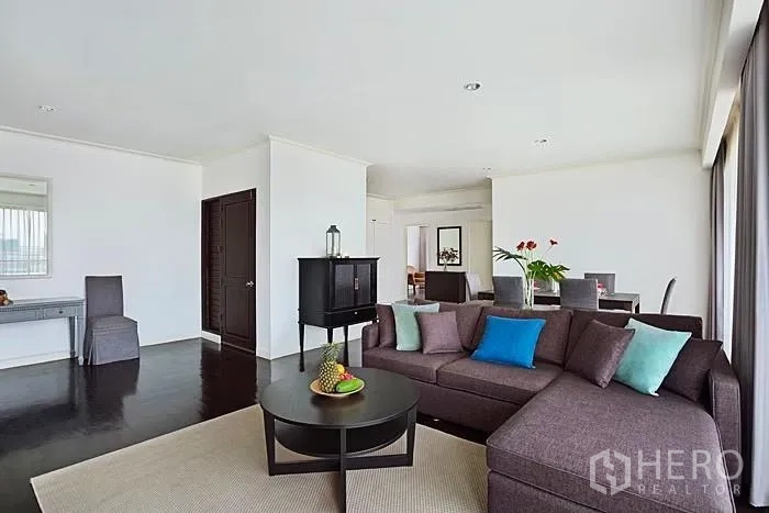 คอนโด ให้เช่าในKhlong San, Bangkok - ห้องนั่งเล่นกว้าง โซฟาเข้ามุม โต๊ะกลางกลม และหน้าต่างบานสูงตลอดแนว