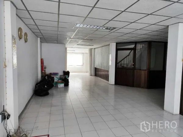 Shophouse for sale in Pathum Thani - Spacious tiled ground floor with office partition and stair access.
