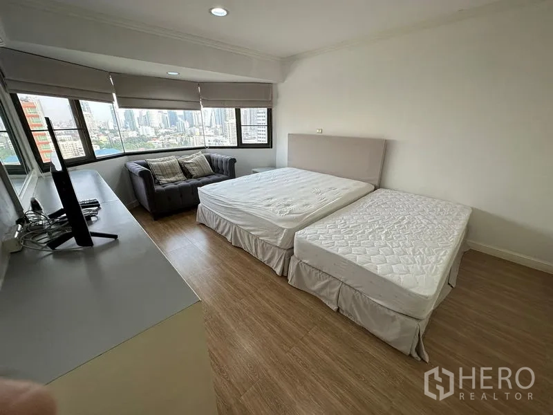 คอนโด ให้เช่าในWatthana, Bangkok - ห้องนอนมุม เตียงคู่ โซฟา และหน้าต่างรอบด้านมองวิวเมืองกว้าง