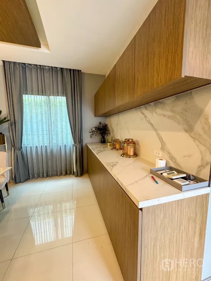 Detached House for rent or sale in Bueng Kum, Bangkok - Pantry with long marble countertop and wood cabinetry beside a large window.