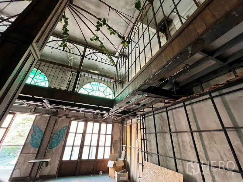 อาคารพาณิชย์ ให้เช่าในWatthana, Bangkok - ห้องโถงสูงโปร่งพร้อมหน้าต่างโค้ง โครงเมซานีนโลหะ และประตูไม้สไตล์วินเทจ.