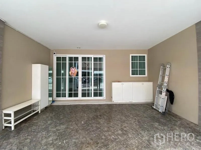 ทาวน์เฮาส์ ให้เช่าในBang Na, Bangkok - พื้นที่จอดรถในร่มหน้าบ้าน พร้อมประตูกระจกบานเลื่อนและตู้เก็บของ