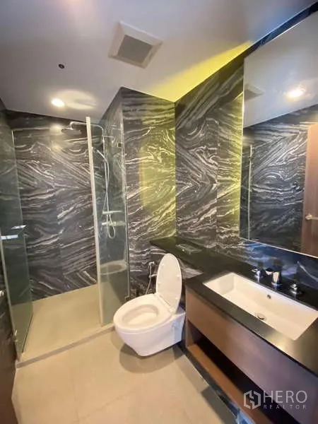 Detached House for rent - Contemporary bathroom with glass shower, marble-pattern tiles and wide vanity.