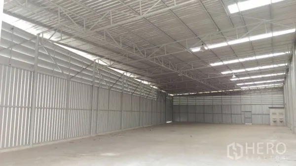 货栈 出租在Lam Luk Ka, Pathum Thani - 仓库内部通透明亮，钢桁架屋顶、百叶通风与采光带，混凝土地面