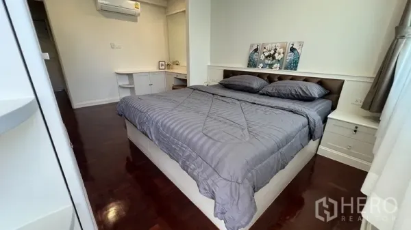 Apartment for rent in Watthana, Bangkok - Second bedroom with double bed, bedside drawers, wall-mounted air conditioner and mirror.