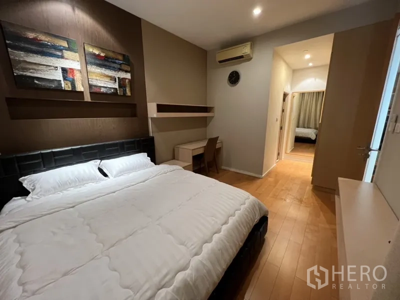 公寓 出租在Chatuchak, Bangkok - 卧室朝走廊视角，内置置物架、书桌与木地板清晰可见。