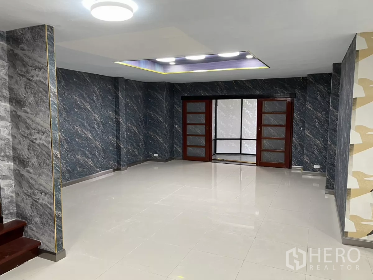 บ้าน ให้เช่าในWatthana, Bangkok - พื้นที่นั่งเล่นพื้นกระเบื้องเงา พร้อมประตูกระจกบานเลื่อนไปยังห้องกระจก.