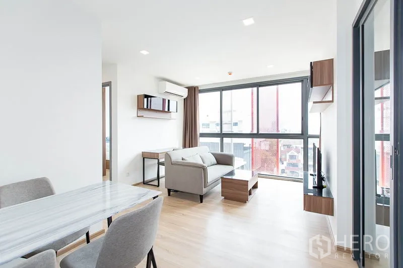 Condominium for rent in Watthana, Bangkok - Open-plan living and dining area with large windows and abundant natural light.