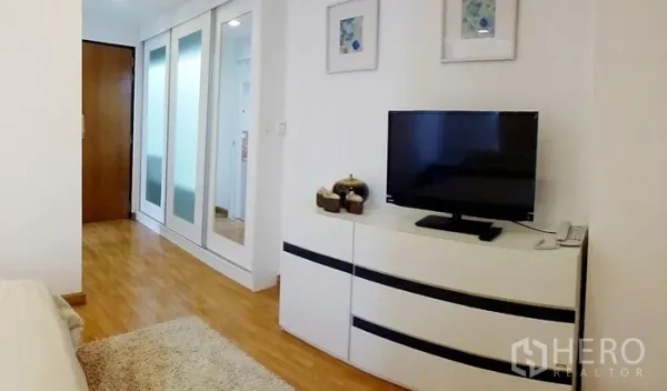 คอนโด ให้เช่าในWatthana, Bangkok - มุมห้องนอนสว่างพร้อมตู้ทีวี ตู้เสื้อผ้าบานเลื่อนกระจก และพื้นไม้ ในคอนโดโซนทองหล่อ เขตวัฒนา กรุงเทพฯ