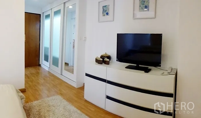 คอนโด ให้เช่าในWatthana, Bangkok - มุมห้องนอนสว่างพร้อมตู้ทีวี ตู้เสื้อผ้าบานเลื่อนกระจก และพื้นไม้ ในคอนโดโซนทองหล่อ เขตวัฒนา กรุงเทพฯ