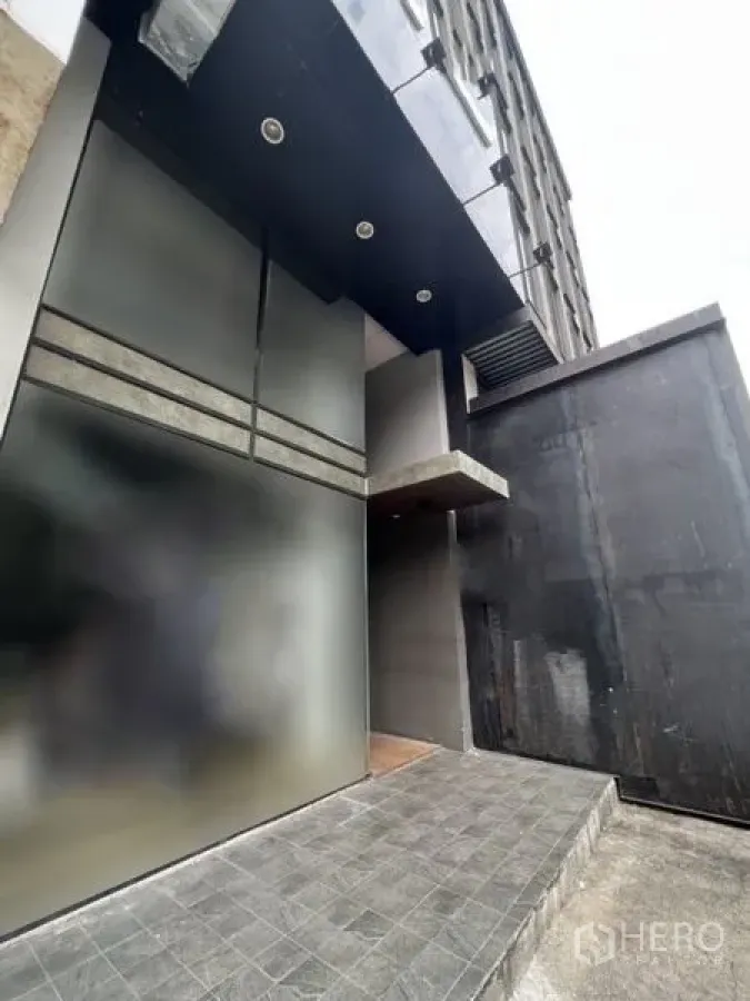 店屋 出租 - 现代店屋入口，深色立面、磨砂玻璃与瓷砖坡道。