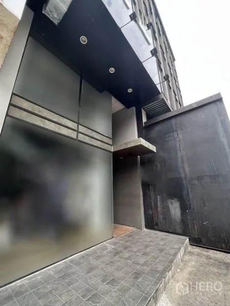 店屋 出租 - 现代店屋入口，深色立面、磨砂玻璃与瓷砖坡道。