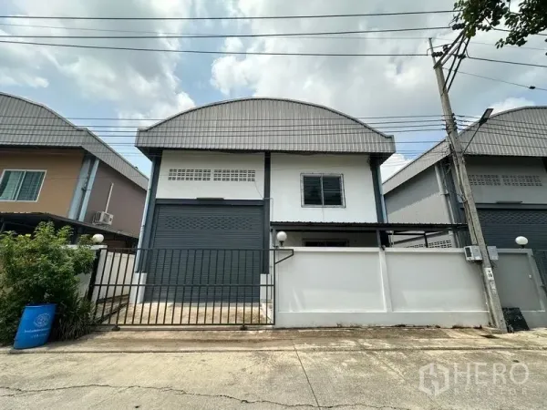 工厂 出租在Bang Bua Thong, Nonthaburi - Pak Kret 迷你工厂外观，带卷闸门、围栏与弧形金属屋顶。