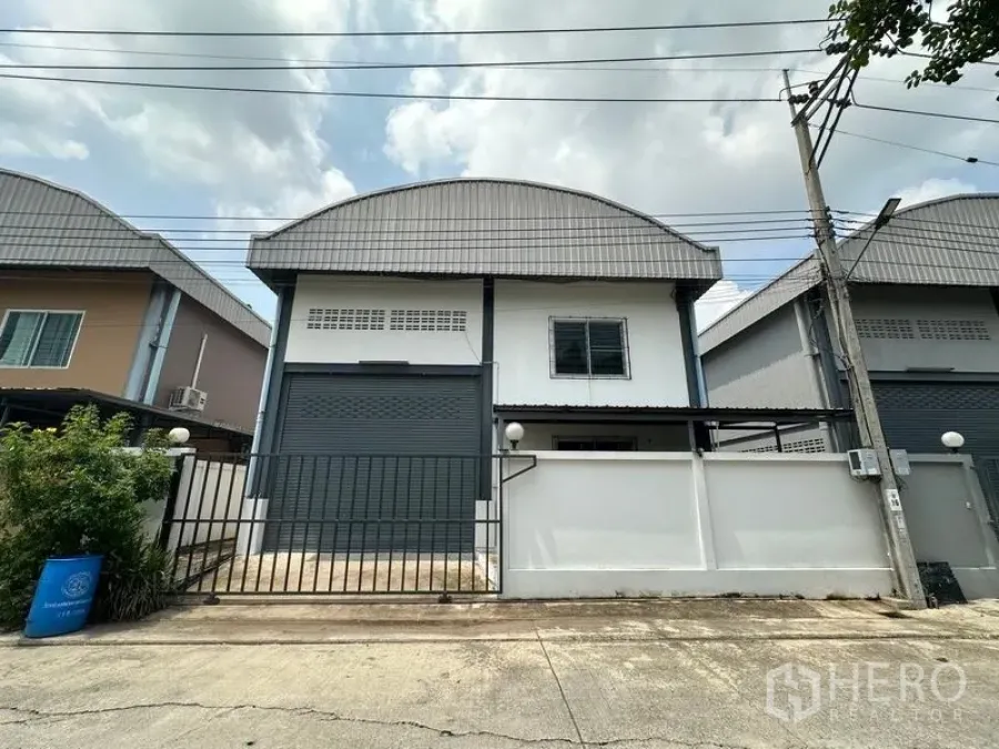 工厂 出租在Bang Bua Thong, Nonthaburi - Pak Kret 迷你工厂外观，带卷闸门、围栏与弧形金属屋顶。