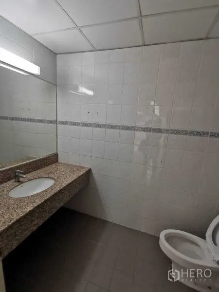 办公空间 出租在Watthana, Bangkok - 卫生间，瓷砖墙面，花岗岩台盆与坐便器。