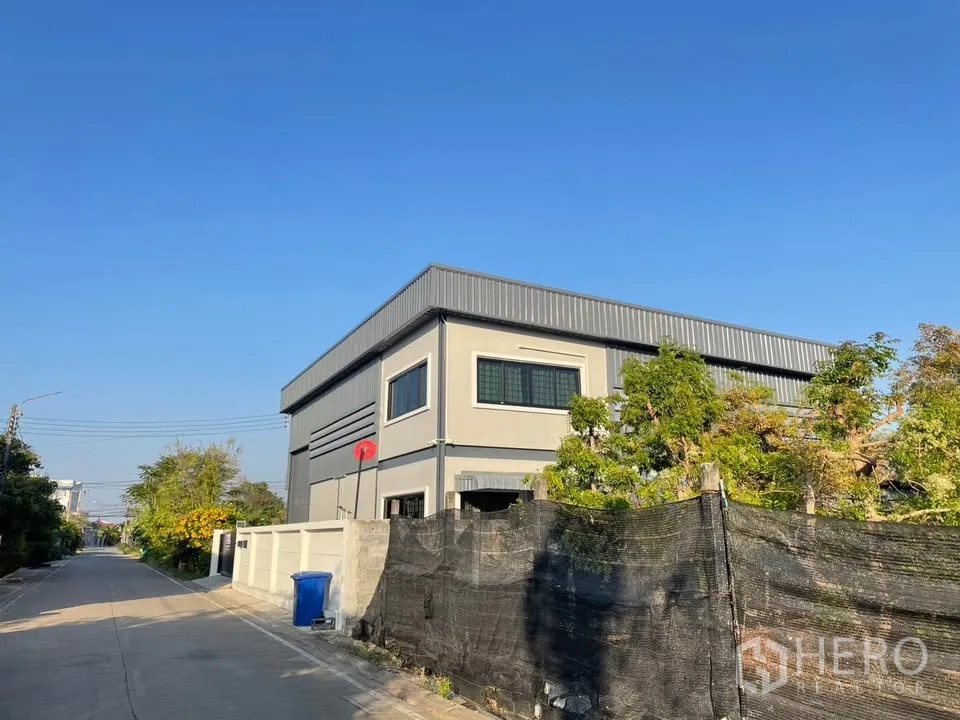 คลังสินค้า for sale in Mueang Nonthaburi, Nonthaburi - โกดังสีเทาทันสมัยบนถนนเงียบสงบ มีรั้วล้อมและต้นไม้รอบด้าน
