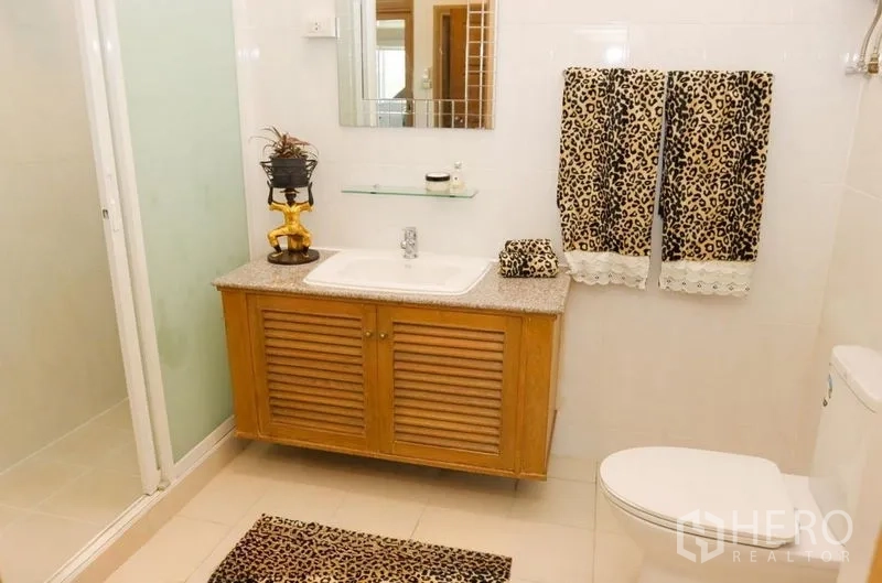 อพาร์ทเมนท์ ให้เช่าในPathum Wan, Bangkok - ห้องน้ำพร้อมตู้ลิ้นชักไม้ อ่างล้างหน้า ฝักบัวกระจก และผ้าเช็ดตัวลายพิมพ์