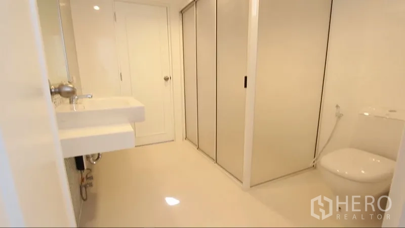 อพาร์ทเมนท์ ให้เช่าในKhlong Toei, Bangkok - ห้องน้ำโทนขาวกว้าง อ่างล้างหน้า โถสุขภัณฑ์ และประตูบานเลื่อนเก็บของ