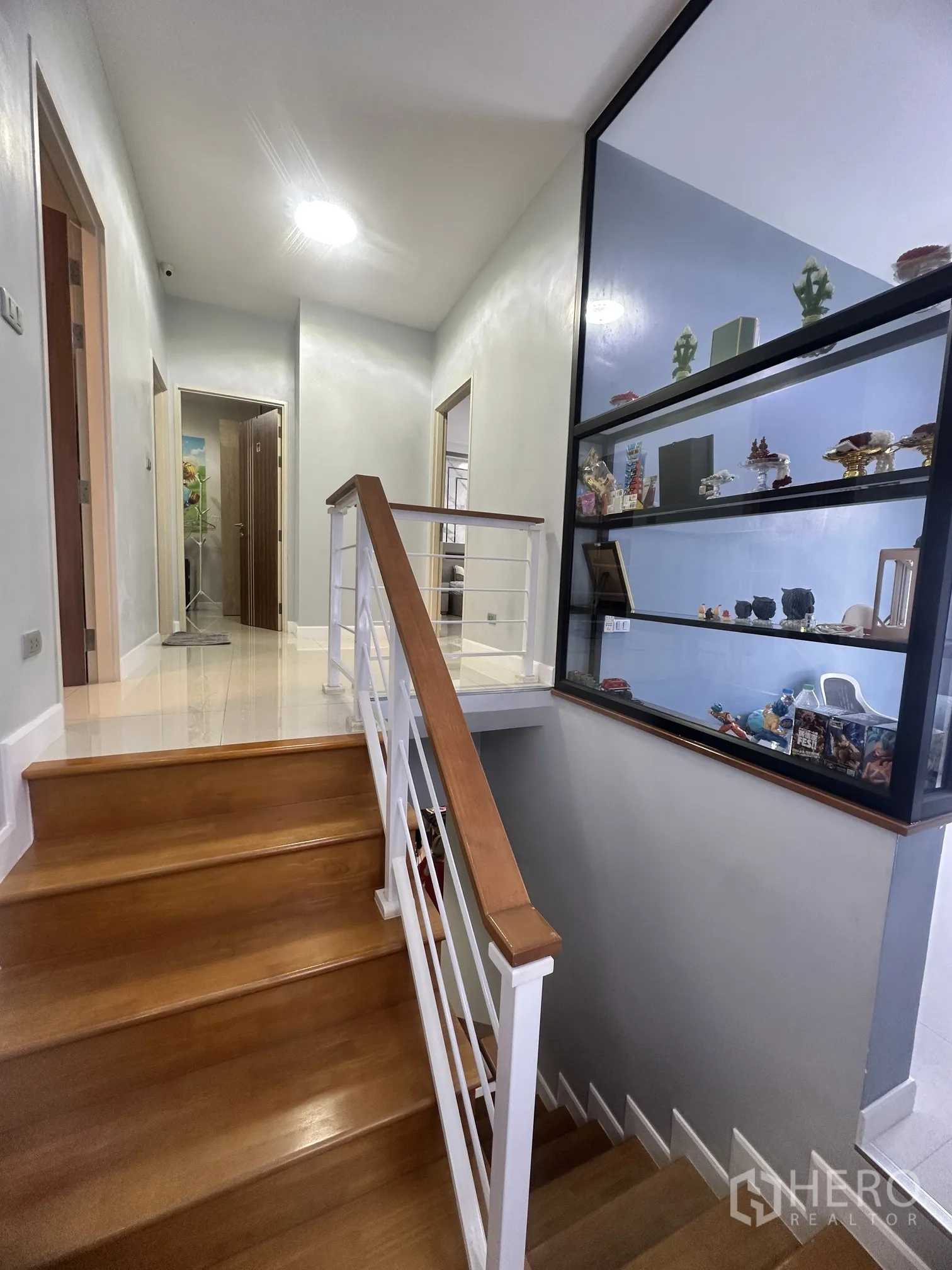 Detached House for sale in Pak Kret, Nonthaburi - Staircase and landing with display shelves and wooden steps.
