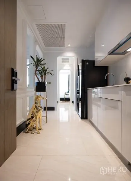 公寓 出租在Bang Rak, Bangkok - 白色廊式厨房，亮面橱柜与石材地面，现代感十足。