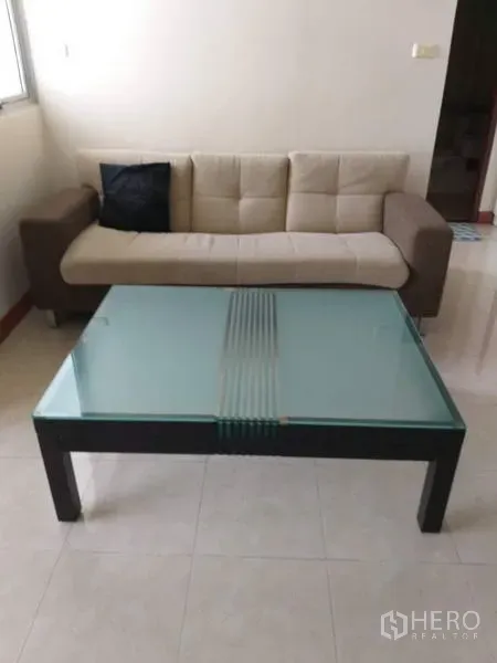 คอนโด ให้เช่าในBang Kho Laem, Bangkok - โซฟาสีเบจคู่โต๊ะกลางกระจก ในห้องนั่งเล่นสว่าง