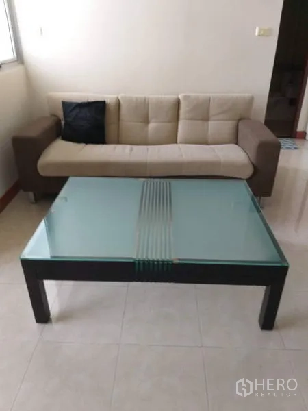 คอนโด ให้เช่าในBang Kho Laem, Bangkok - โซฟาสีเบจคู่โต๊ะกลางกระจก ในห้องนั่งเล่นสว่าง