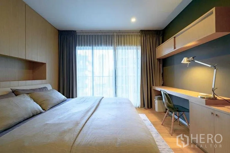 公寓 出租在Watthana, Bangkok - 明亮卧室，特大床、落地窗、内置书桌与纱帘。