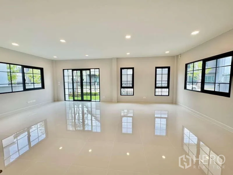 Detached House for sale in Bang Phli, Samut Prakan - Open-plan living and dining area with glossy white tile floors and multiple windows.