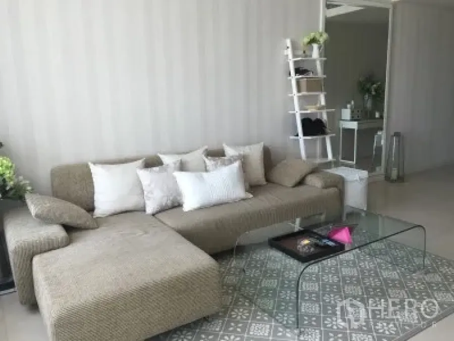 公寓 出租或出售在Ratchathewi, Bangkok - 明亮客厅，L形沙发、玻璃茶几与图案地毯。