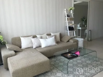 公寓 出租或出售在Ratchathewi, Bangkok - 明亮客厅，L形沙发、玻璃茶几与图案地毯。