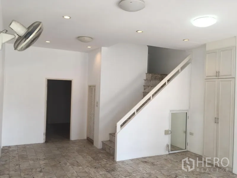 ทาวน์เฮาส์ ให้เช่าในChatuchak, Bangkok - ห้องนั่งเล่นชั้นล่างสว่าง พื้นลายหินอ่อน ไฟดาวน์ไลต์ และบันไดขึ้นชั้นบน