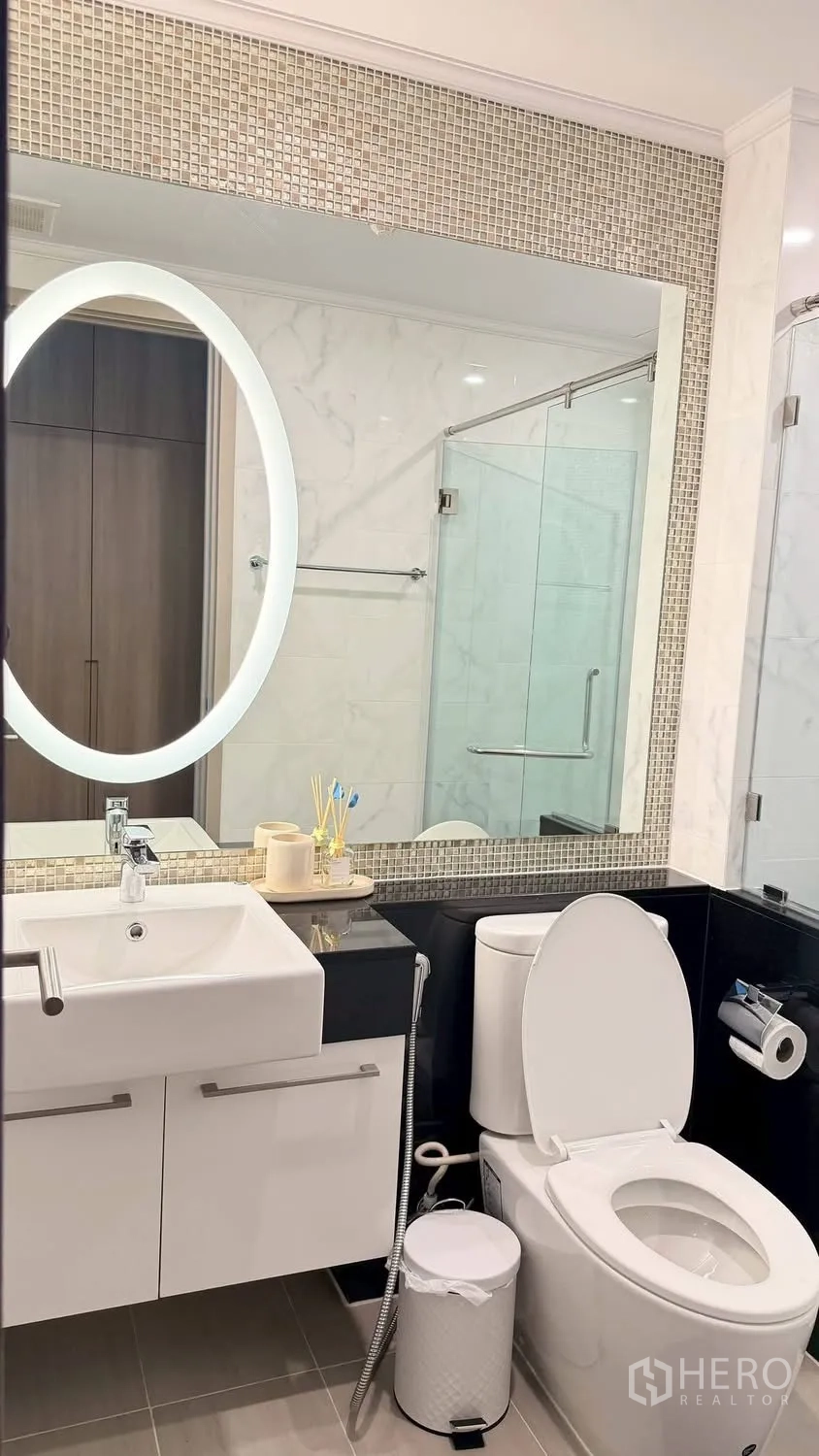 Condominium for rent in Watthana, Bangkok - Contemporary bathroom with illuminated mirror, vanity, and glass shower.