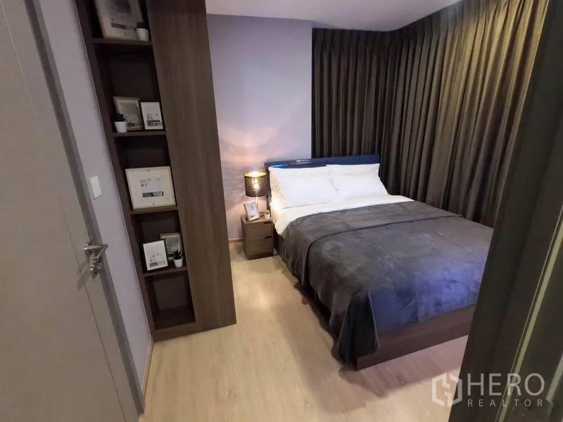 คอนโด ให้เช่าหรือขายในWatthana, Bangkok - มองจากประตูเข้าห้องนอน เห็นพื้นไม้ ชั้นวางของ และโต๊ะหัวเตียง