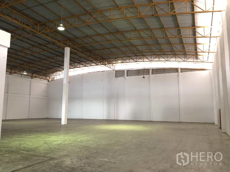 货栈 出租在Phra Nakhon Si Ayutthaya - 仓库内部空间开阔，钢结构高屋顶、白色墙面与混凝土地坪。