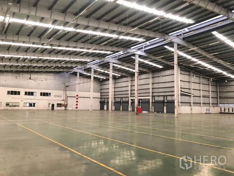 工厂 出租在Phra Nakhon Si Ayutthaya - 开放式生产区，高净空钢柱结构，侧边设有办公区域。