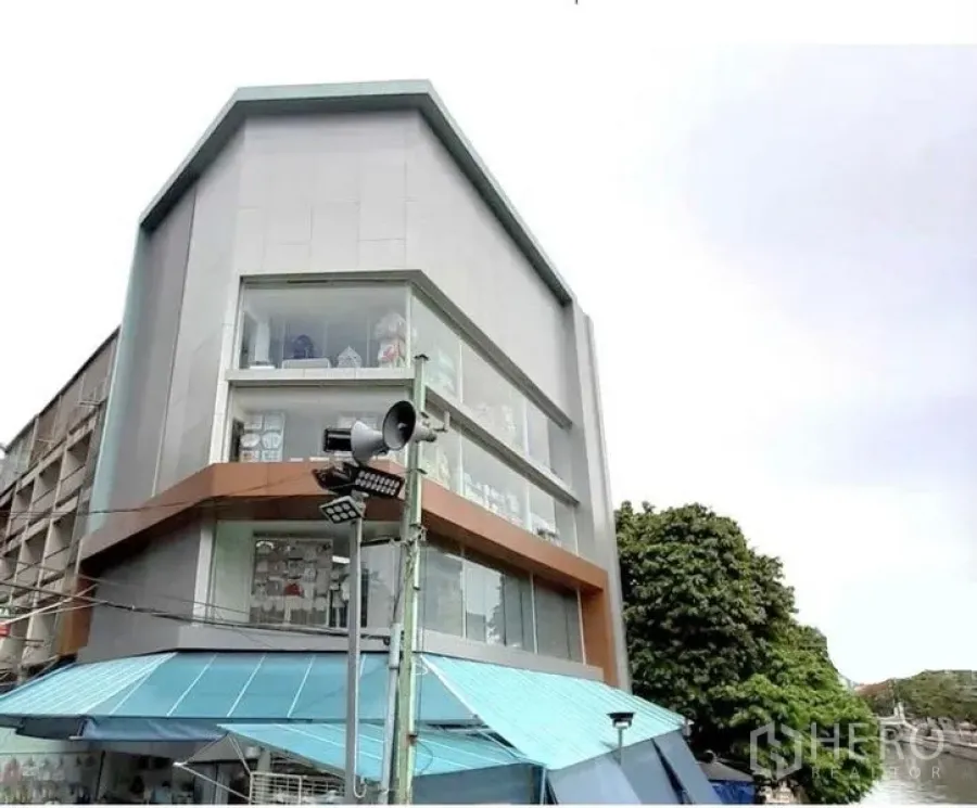 店屋 出租在Pathum Wan, Bangkok - 多层商铺外立面斜角视图，配大面积展示窗与简洁线条。