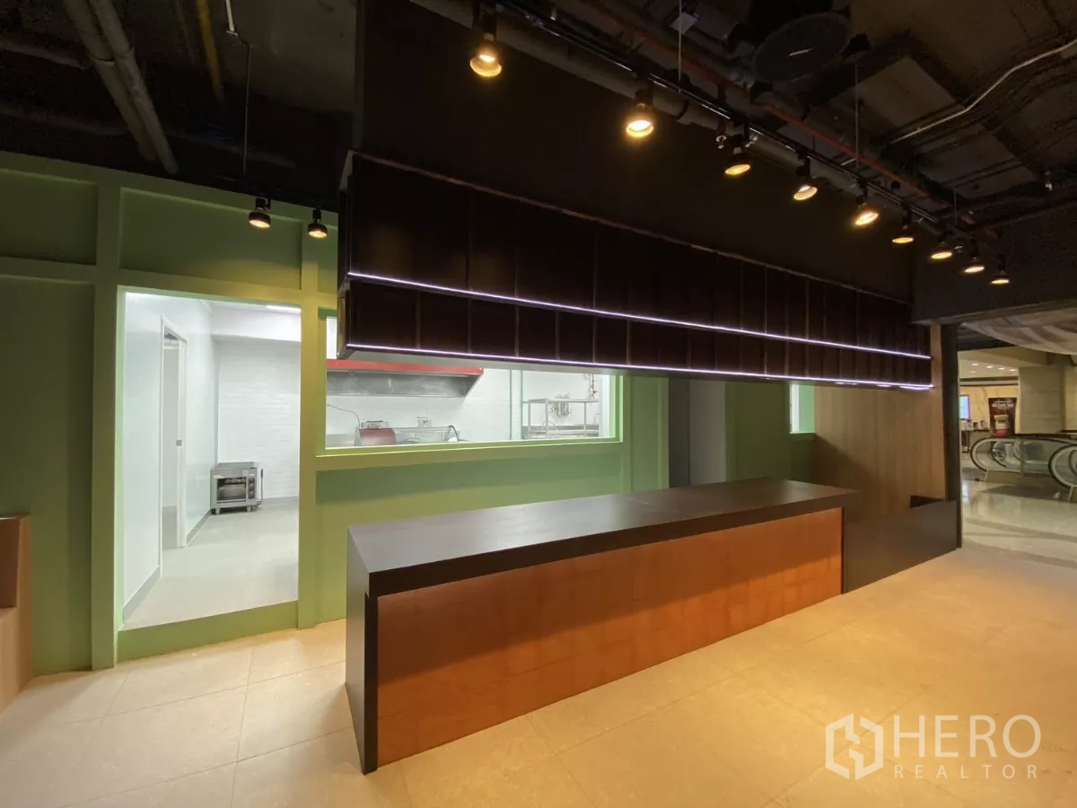 零售空间 出租 - 门口接待台与悬吊柜，旁连后厨，外部有扶梯